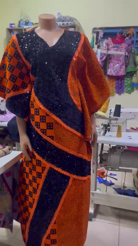 Orange and black patterned outfit with statement sleeves.